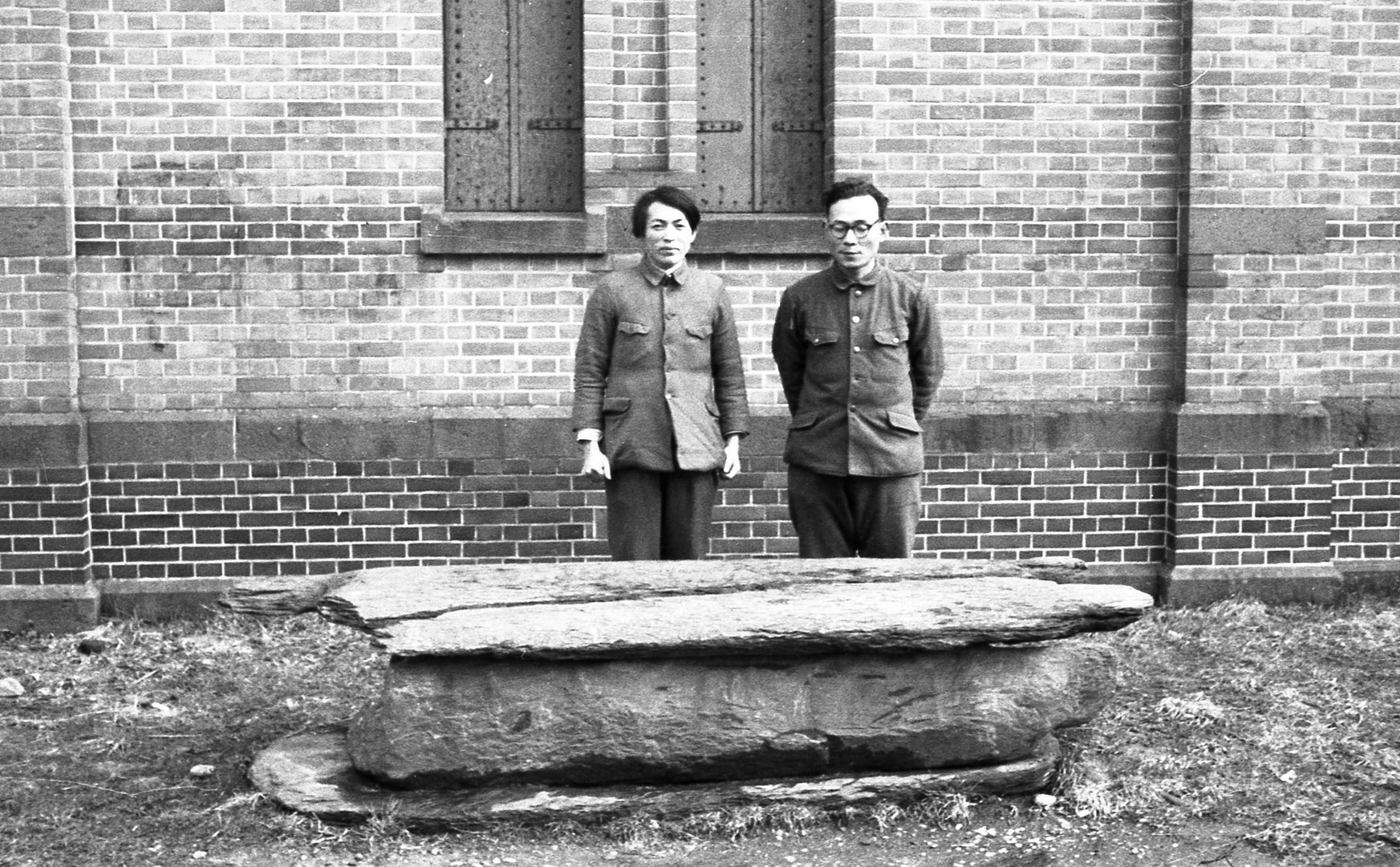 赤煉瓦書庫の隣に移設された石棺。工藤雅樹（左）と加藤孝（右）